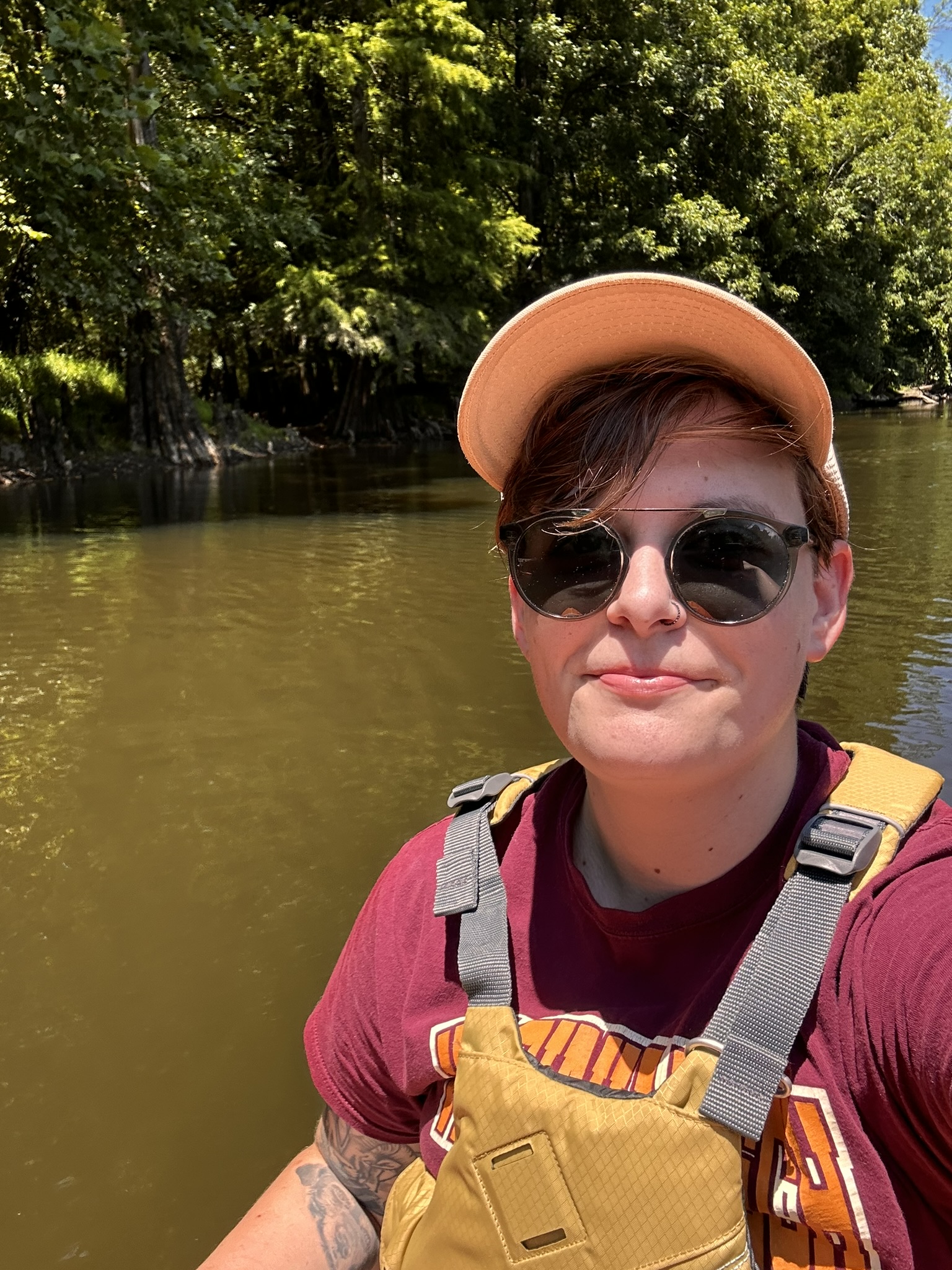 Kit in a hat , sunglasses, and life vest on water 